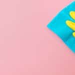 Hand in glove on pink background. Cleaning concept